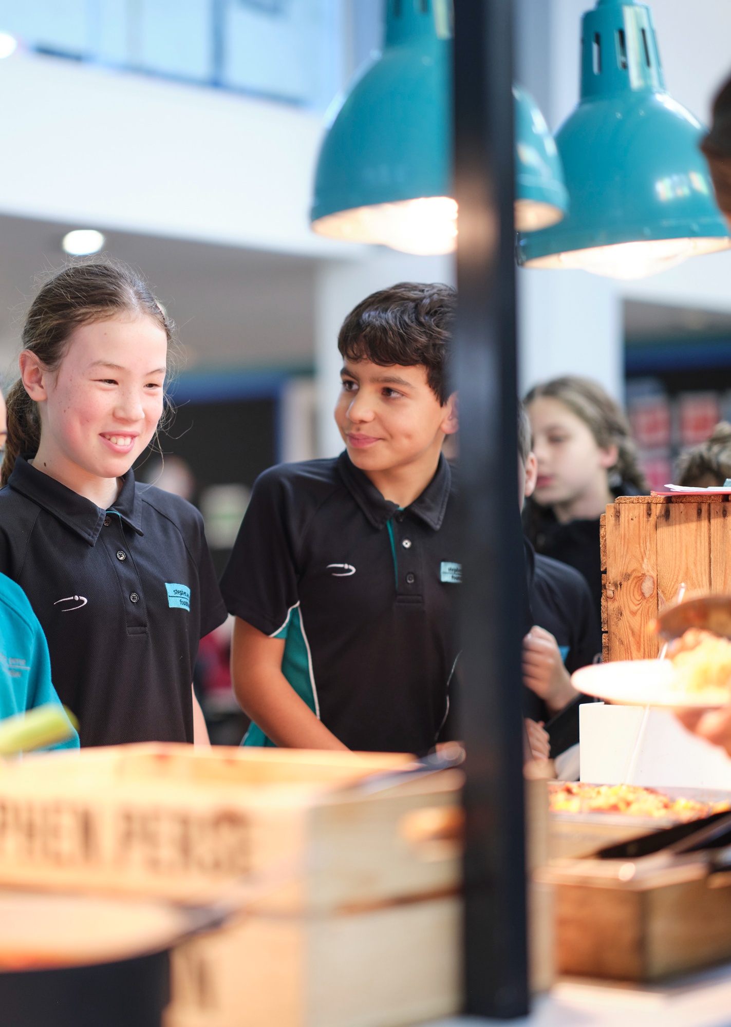 Pupils in the dining room at the Cambridge Junior School linking to the Junior School Menu